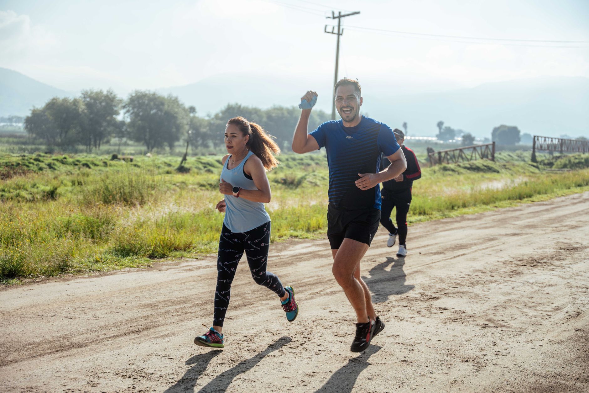 woman and man running in race on dirt road